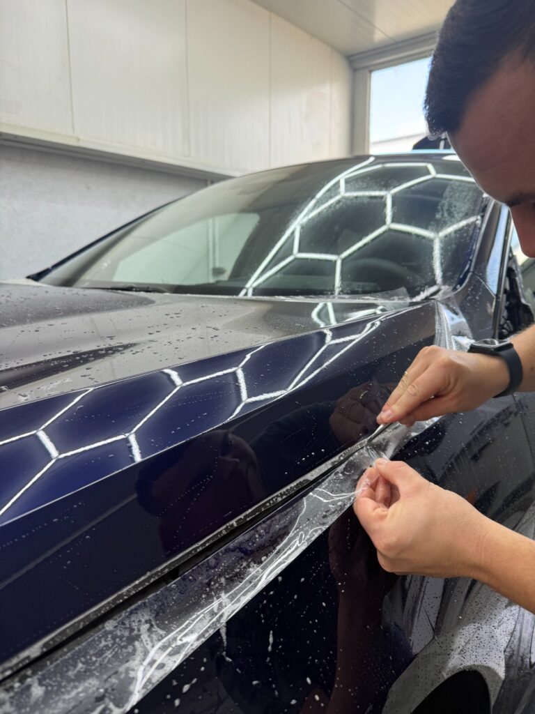 Dopasowanie folii PPF przy krawędzi maski BMW serii 1 2026