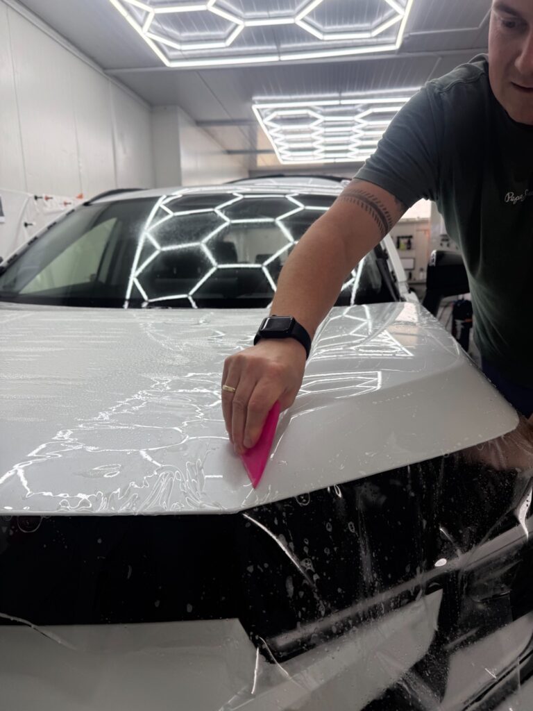 Dopasowanie folii PPF raklą do powierzchni maski Toyoty RAV4 2026