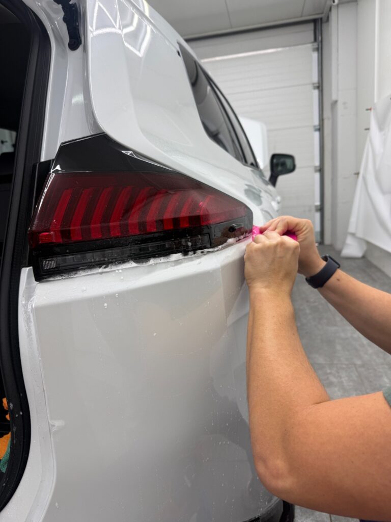 Aplikacja folii PPF przy tylnej lampie białej Toyoty RAV4 2026