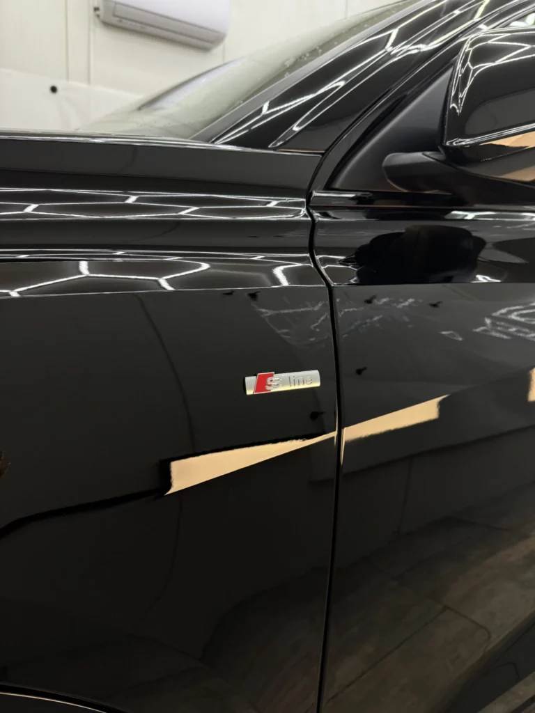 Czarny błyszczący bok Audi Q8 z emblematem S line i lusterkiem
