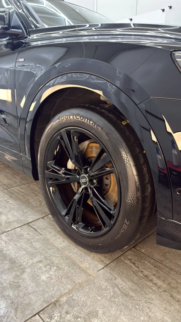 Czarna lakierowana felga Audi Q8 i błyszczący przedni błotnik
