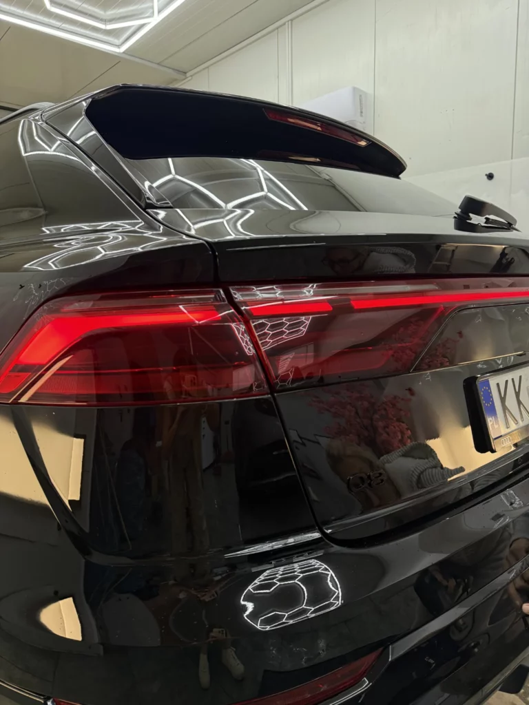 Tylna lampa i spojler Audi Q8 na tle czarnego błyszczącego nadwozia