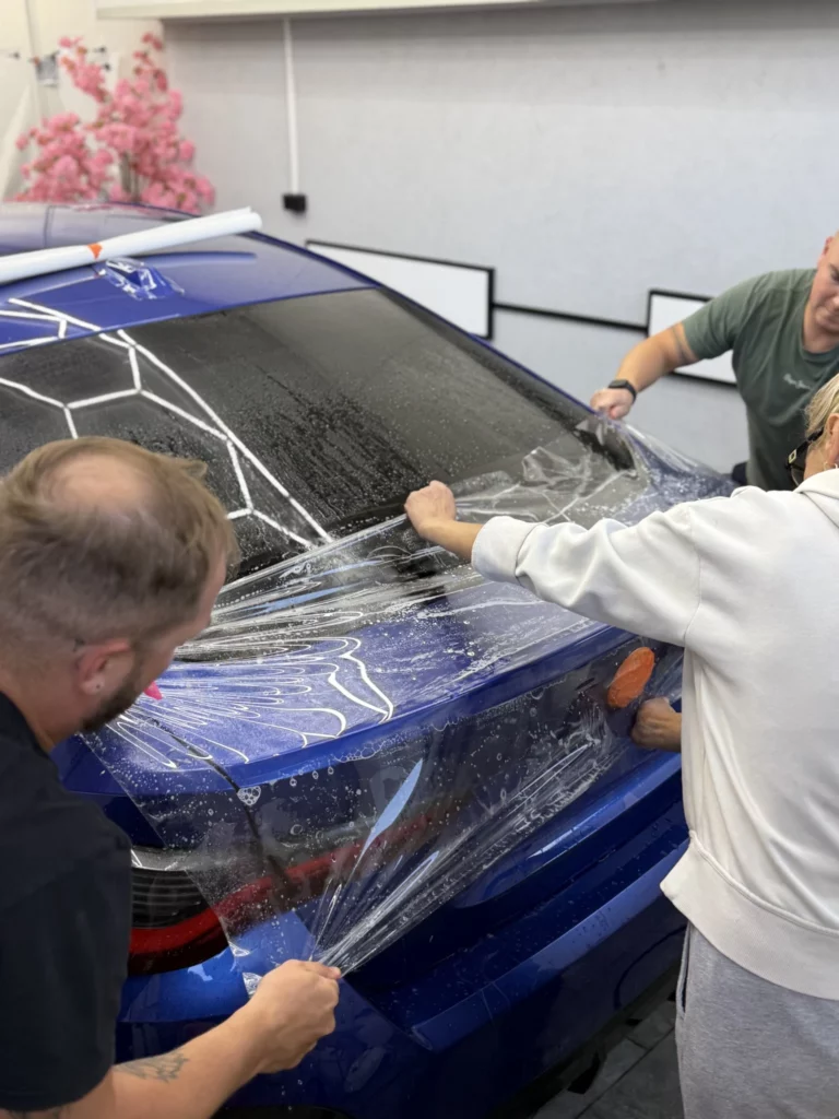 Instalatorzy nakładają folię PPF na klapę bagażnika BMW serii 4