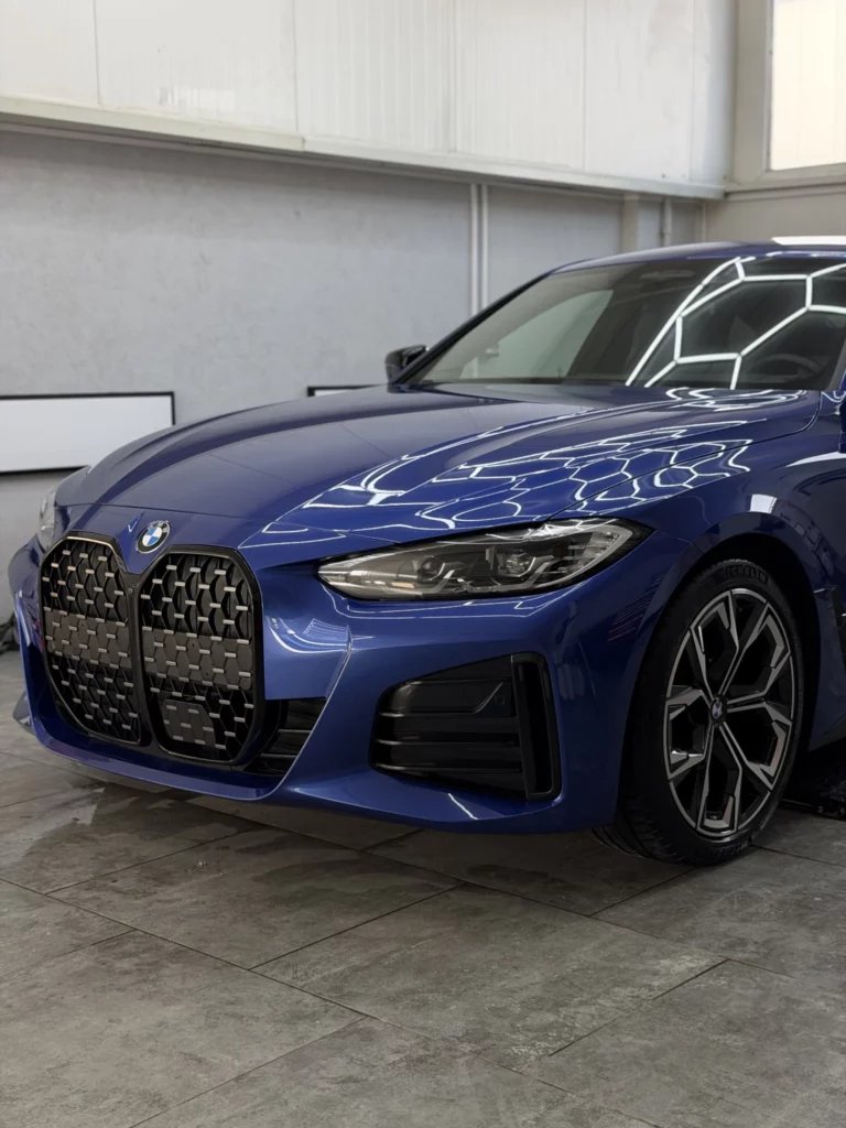 Przedni zderzak, reflektor i koło niebieskiego BMW serii 4 po zabezpieczeniu
