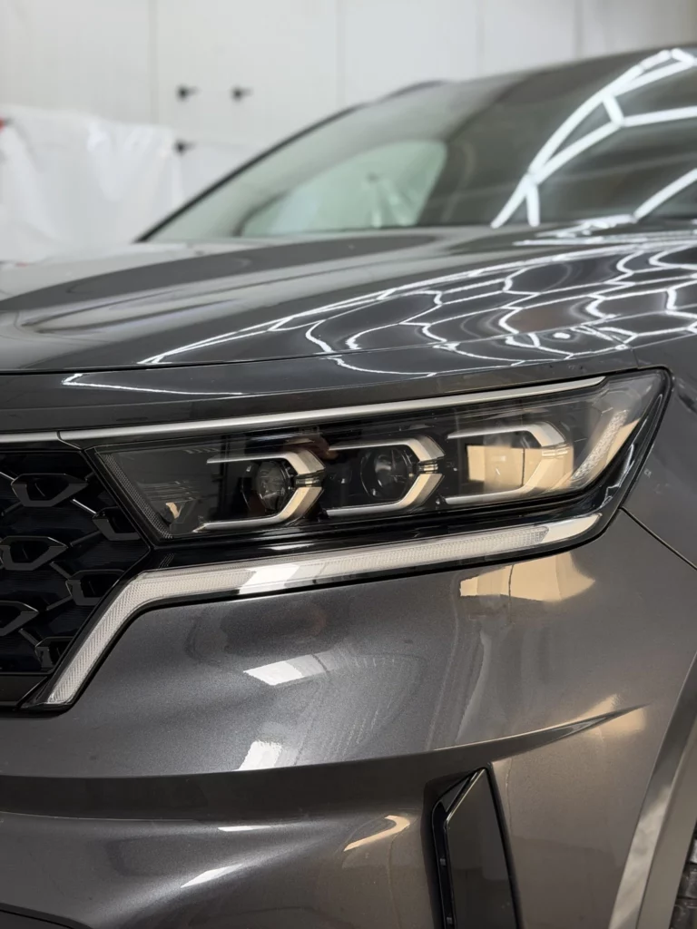 Zbliżenie przedniego reflektora i zderzaka Kia Sorento