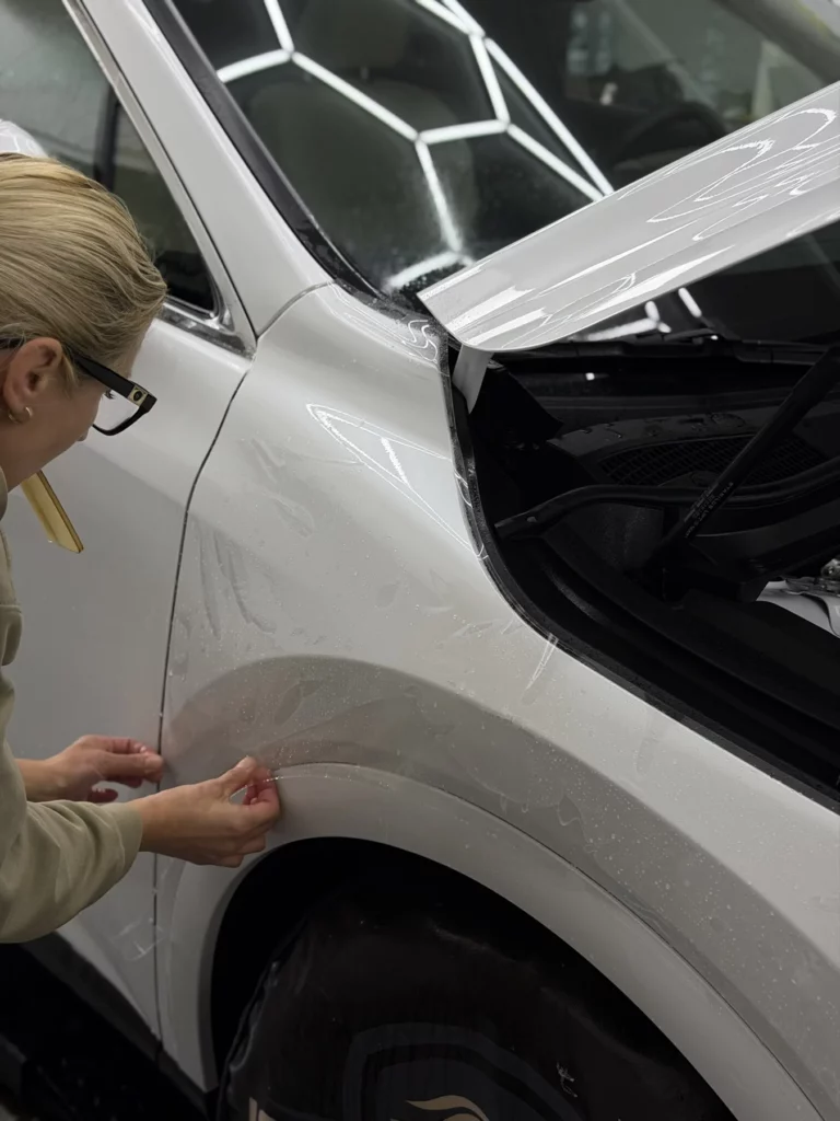 Wykańczanie folii przy krawędzi przedniego nadkola Lexusa RX 450
