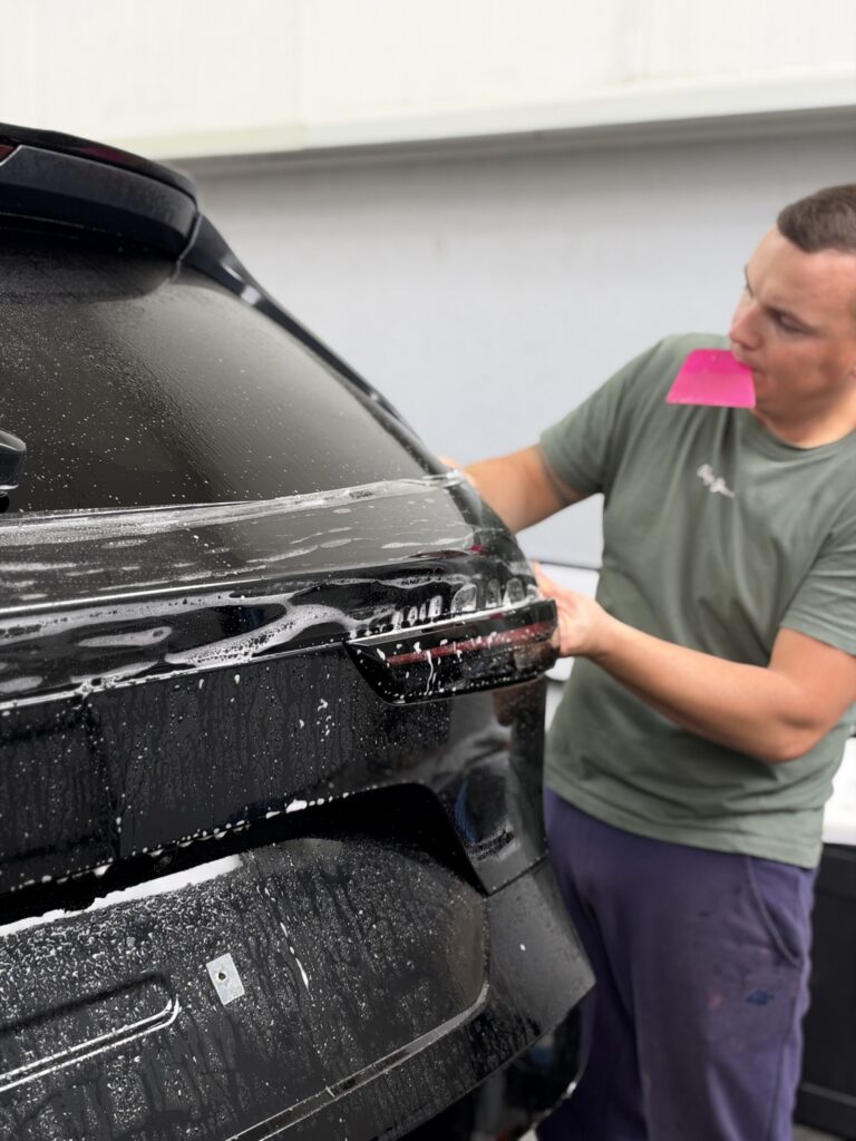 Układanie folii ochronnej na klapie bagażnika Mazdy CX-5