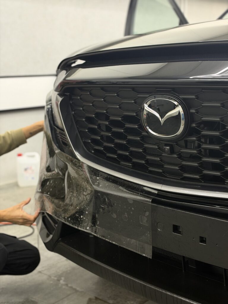 Przedni grill i zderzak Mazdy CX-5 podczas montażu PPF