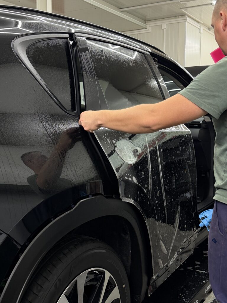 Układanie folii na drzwiach przy tylnym nadkolu Mazdy CX-5