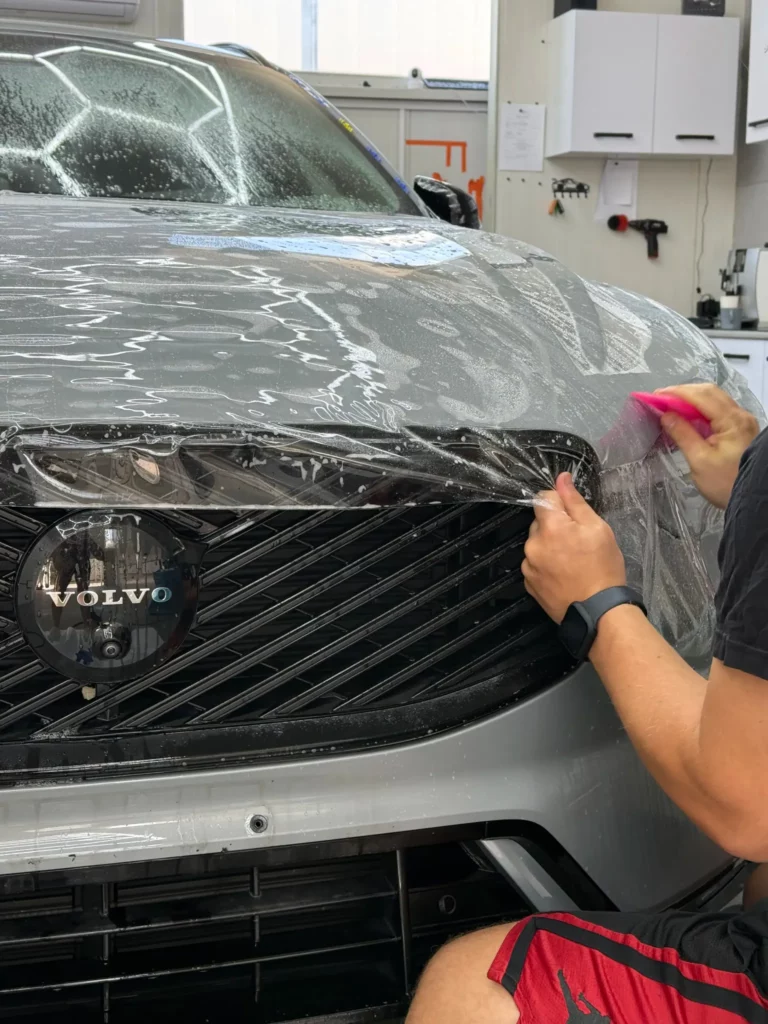 Wygładzanie folii PPF raklą przy przedniej krawędzi maski Volvo XC60
